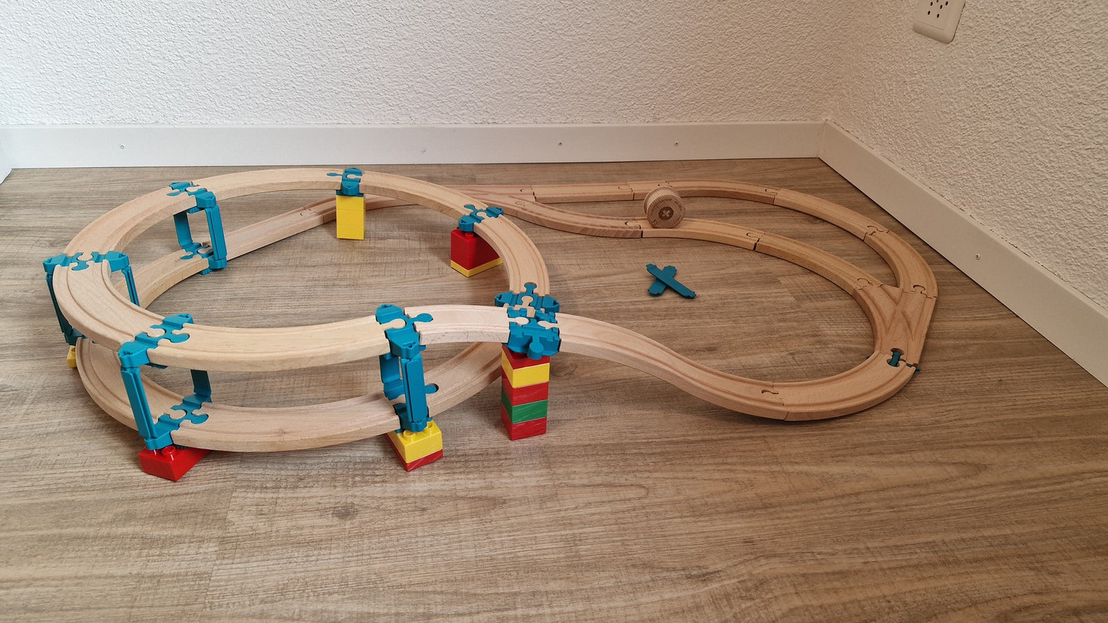 Bouwvoorbeeld met één Yamba Helix-lus en houten treinrails op gekleurde bouwstenen